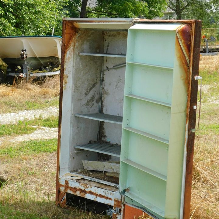 Rusted old refrigerator standing in a yard